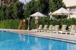 Outdoor pool, pool umbrellas, sun loungers - Radisson Blu Hotel Doha (Doha)