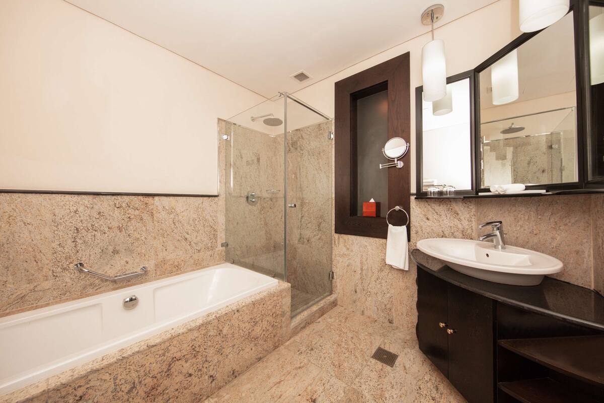 A modern bathroom with a bathtub, a sink, and a glass-enclosed shower.