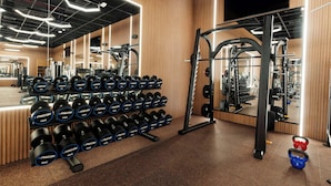 A gym with weight racks, dumbbells, and exercise equipment.