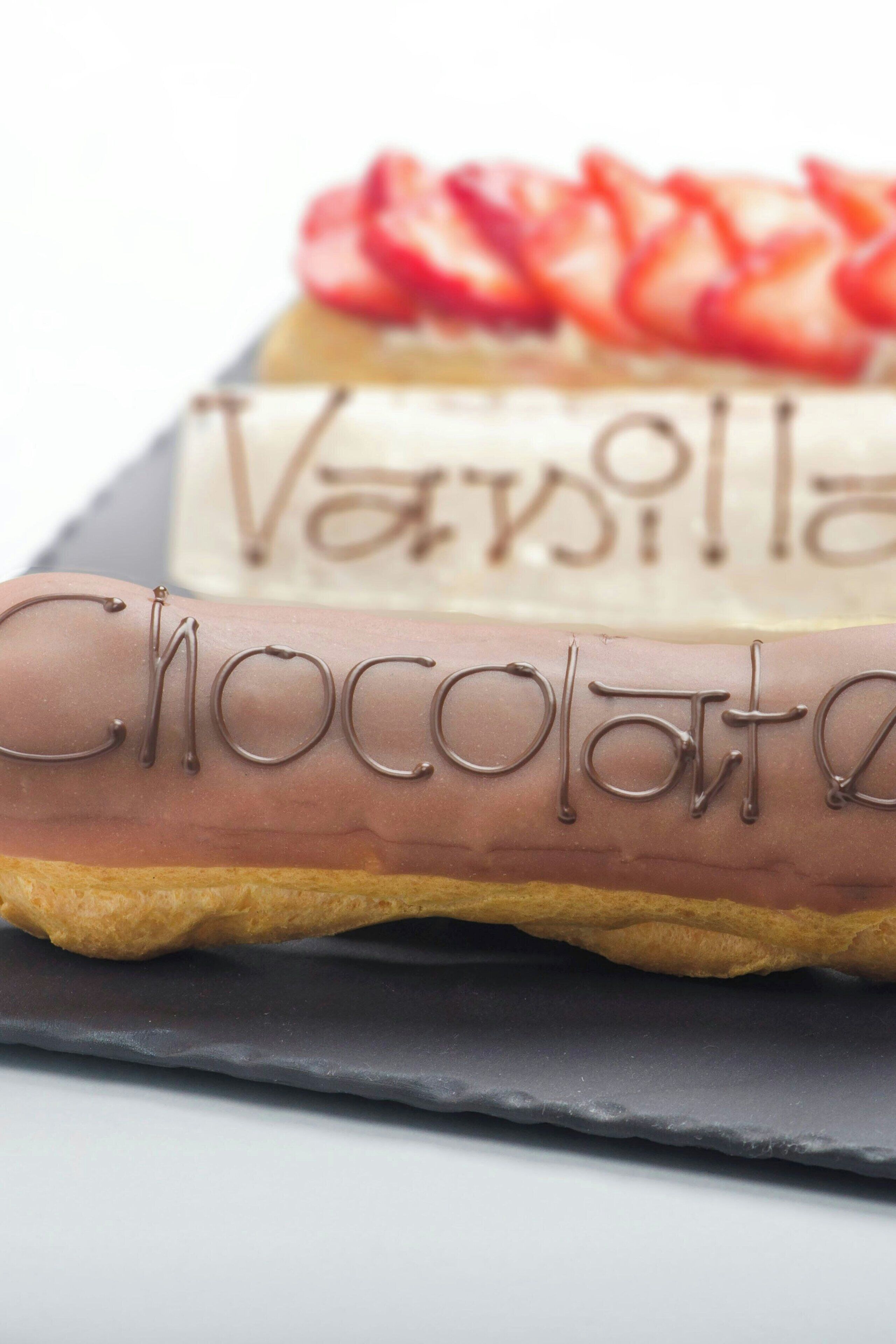 Three pastries with chocolate, vanilla, and strawberry toppings.