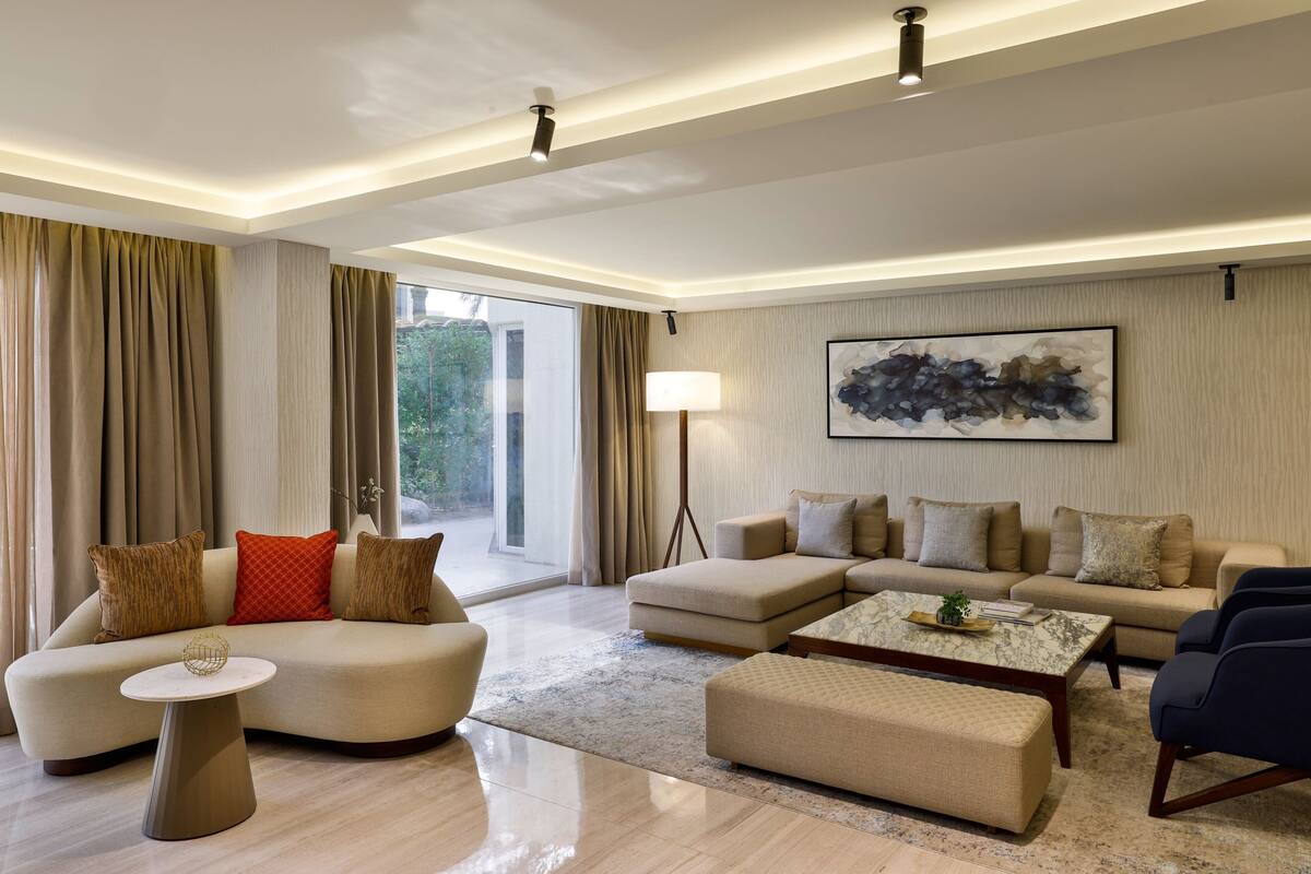 A modern living room with a sectional sofa, a round coffee table, and a floor lamp.