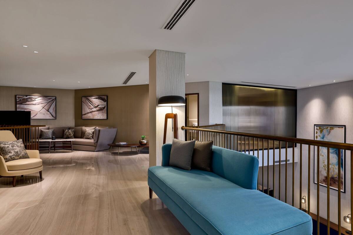 A modern living room with a sofa, armchair, and a coffee table.