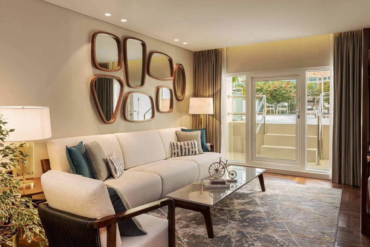A modern living room with a sofa, coffee table, and decorative mirrors.