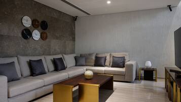 Ein modernes Wohnzimmer mit einer Couch, einem Couchtisch und Wanduhren.