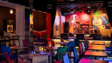 Un restaurante con escenario, mesas y sillas.
