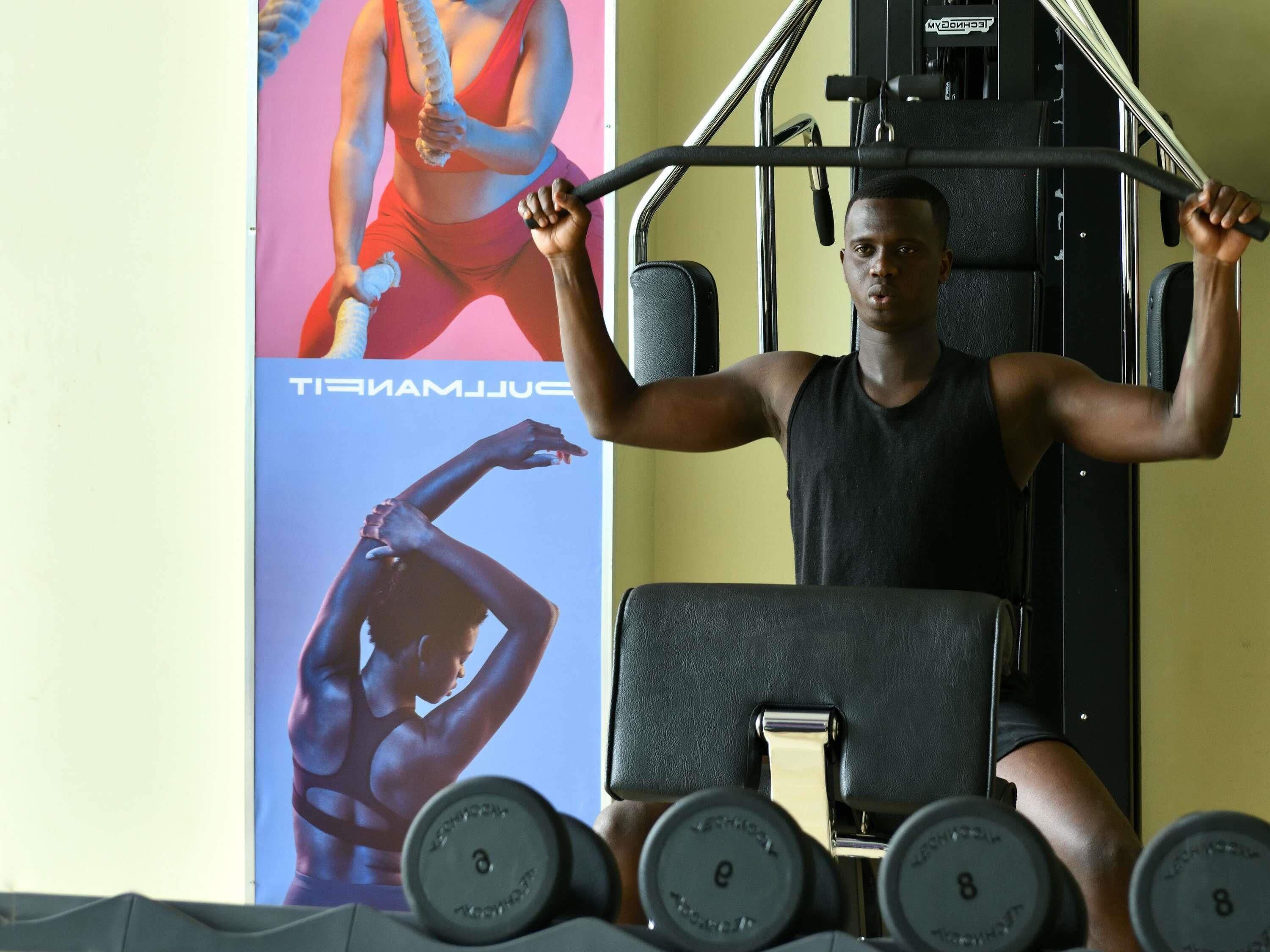 A gym with exercise equipment and a poster of a woman in workout attire.
