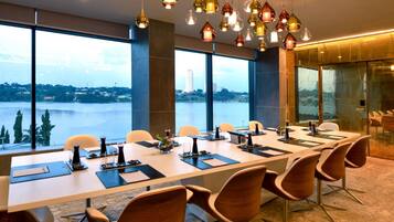 A conference room with a long table, chairs, and a view of a body of water.