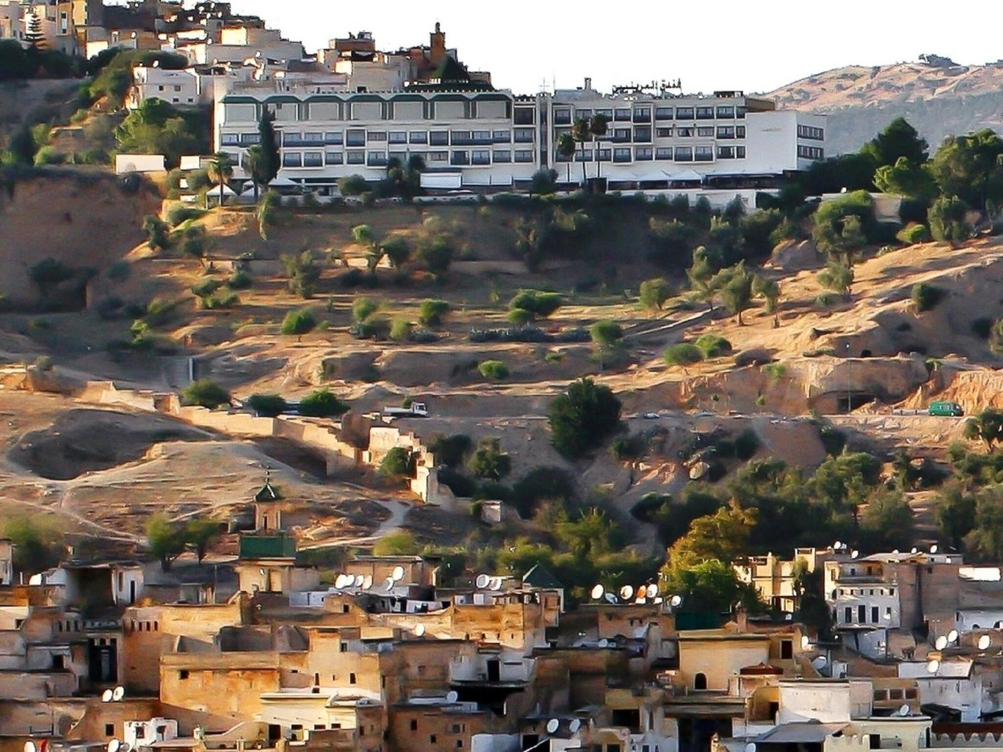 Un asentamiento en una ladera con construcciones tradicionales, incluyendo edificios de techos planos y antenas parabólicas.