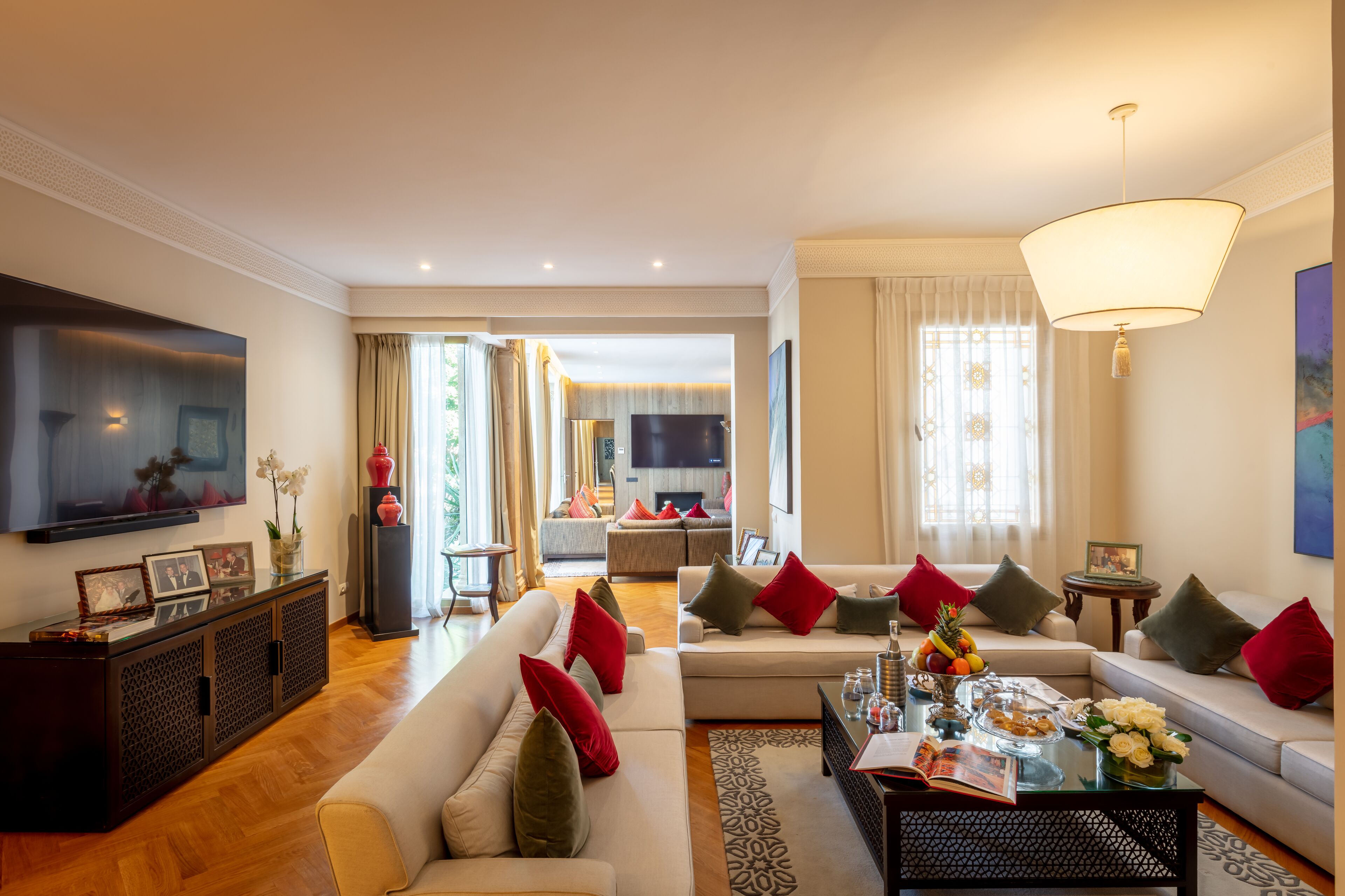 A spacious living room with a large flat-screen TV, comfortable seating, and a dining area with a coffee table.