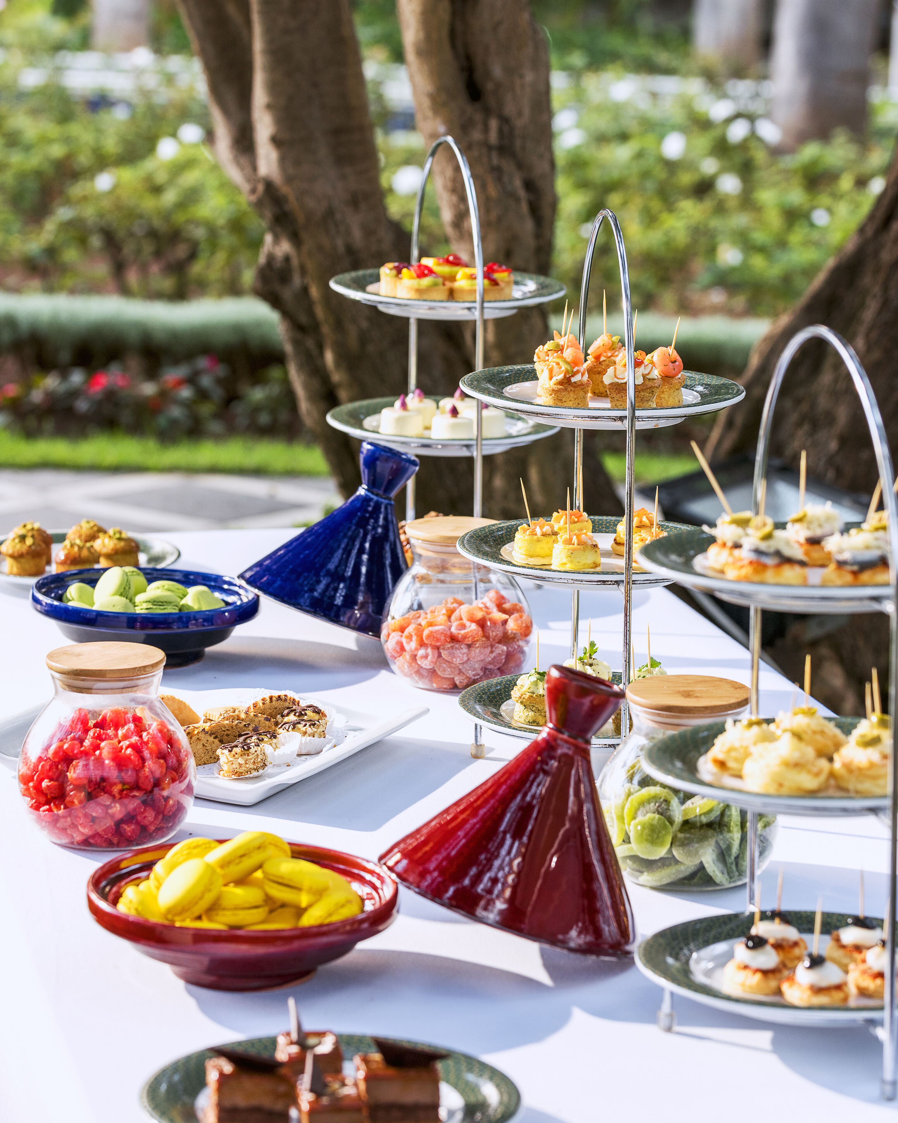 A buffet table with various food items and a decorative vase.