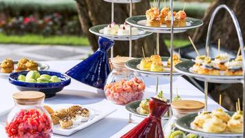 A buffet table with various food items and a decorative vase.