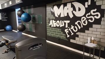 Ein Fitnessraum mit einer motivierenden Wand, Übungsbällen und einer Gewichtbank.