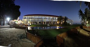 A hotel with a pool, outdoor seating, and a view of the ocean. - Wilderness Beach Hotel (Wilderness)