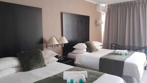 Una habitación de hotel con dos camas, un escritorio, una silla y una mesa.