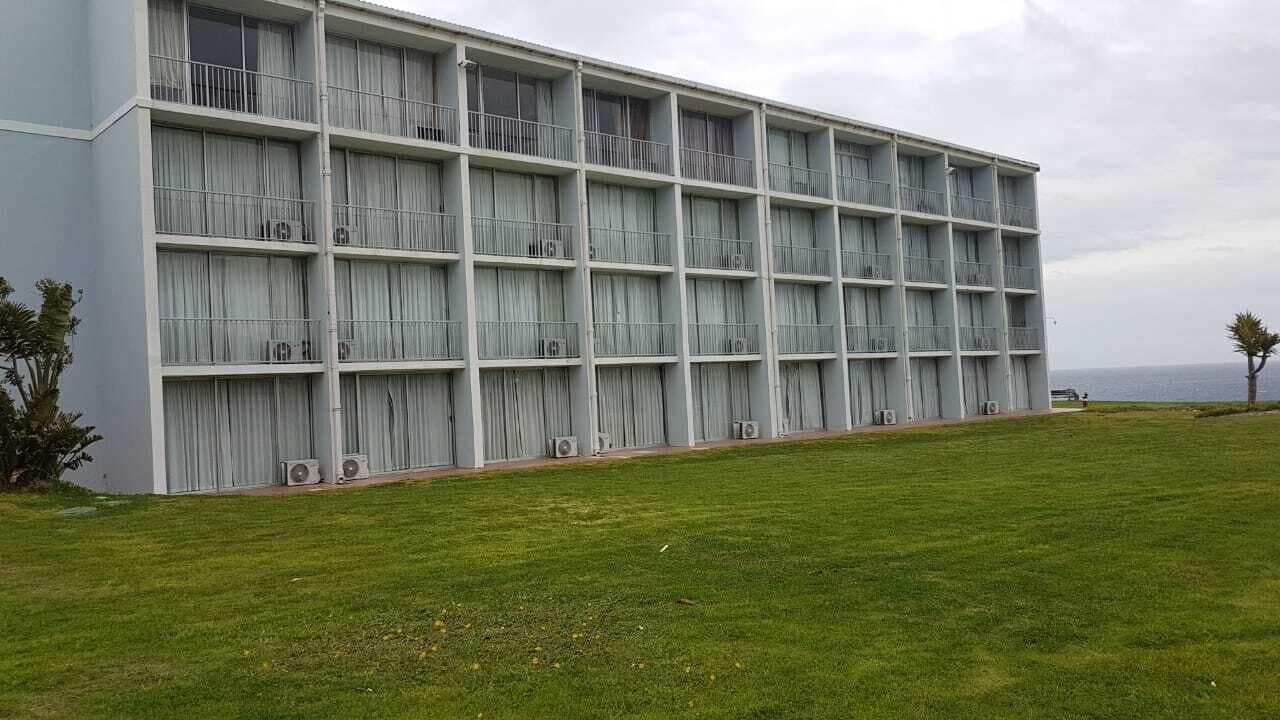 A large, modern building with multiple balconies and air conditioning units.
