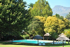 Una piscina al aire libre, camas de piscina gratis, sombrillas