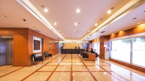 A spacious lobby with a polished floor, a reception desk, seating area, and an elevator. - Gloria Prince Hotel Taipei (Taipei)