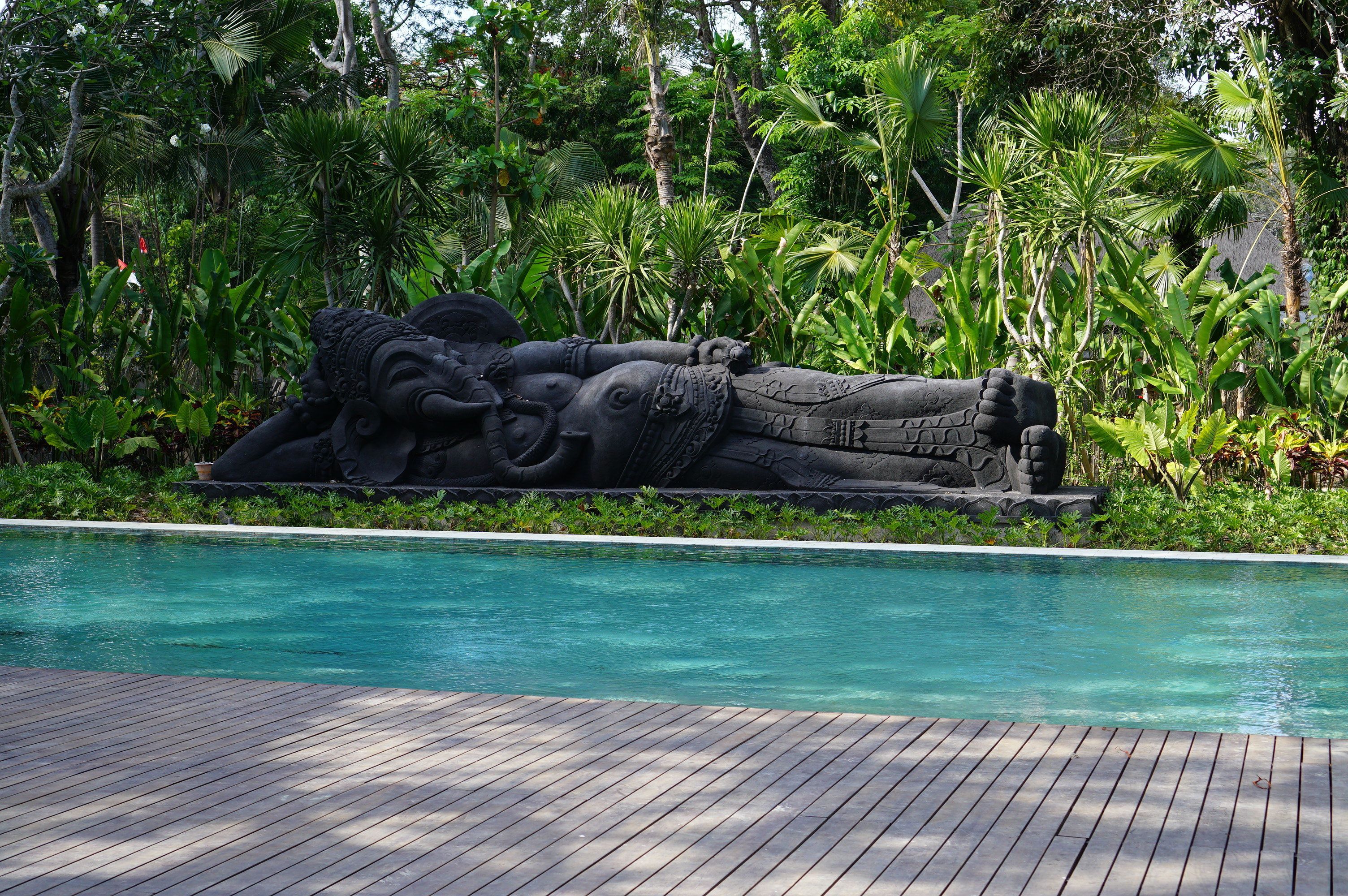Una piscina con una escultura de piedra de una figura reclinada.