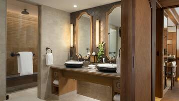 Un baño moderno con lavamanos doble, espejos grandes y un perchero para toallas.