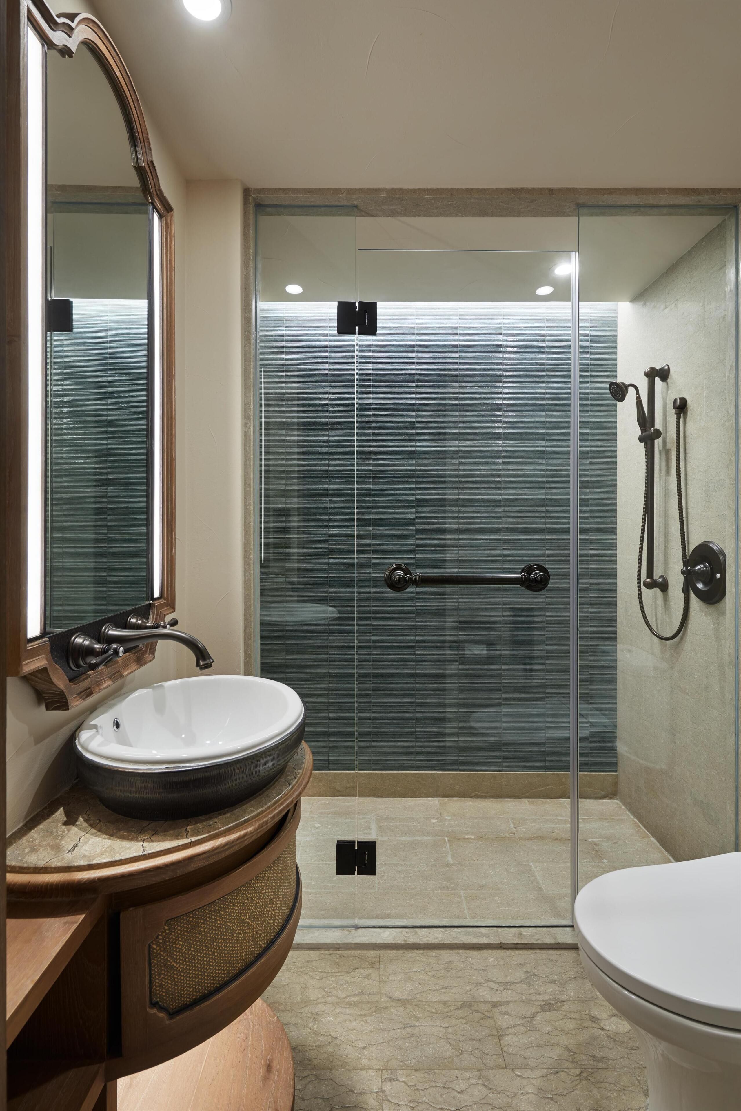 Une salle de bain moderne avec une douche à parois de verre, un lavabo blanc et des toilettes.