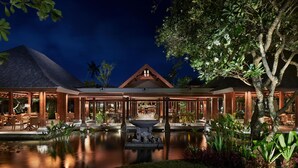 A resort with a pool, outdoor seating, and a gazebo.