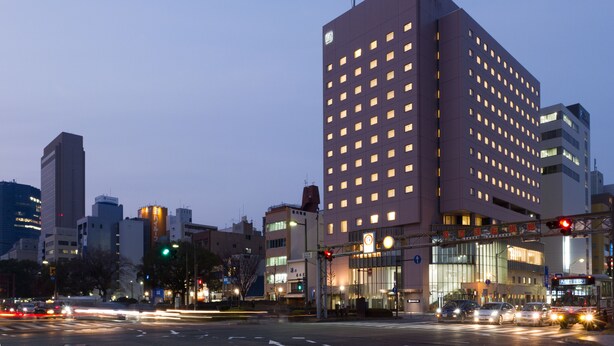 A modern hotel with a prominent corner location, multiple floors, and a well-lit facade. - Hiroshima Tokyu REI Hotel (Hiroshima)