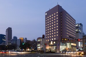 A modern hotel with a prominent corner location, multiple floors, and a well-lit facade. - Hiroshima Tokyu REI Hotel (Hiroshima)