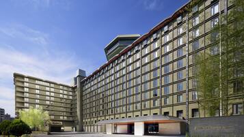 A multi-story hotel with a modern architectural design, featuring a prominent entrance and a clear sky.