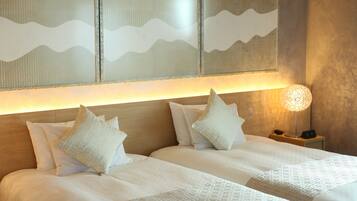 A hotel room with two beds, a nightstand with a lamp, and a wall with a textured design.