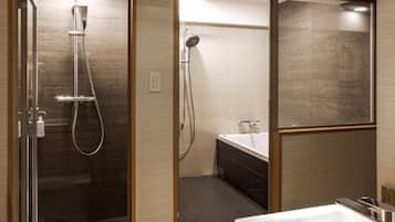 A modern bathroom with a glass-enclosed shower, a separate bathtub, and a vanity with a mirror.