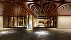 Un moderno vestíbulo de hotel con techo de listones de madera, puertas de cristal y piso de baldosas.
