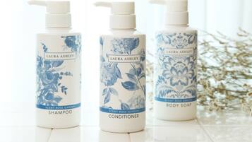 Three bottles of Laura Ashley body care products: shampoo, conditioner, and body soap.