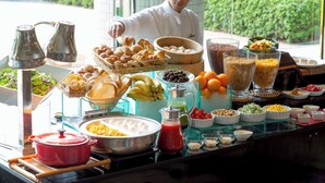 A buffet with various food items and a chef preparing food.