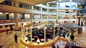 A multi-level hotel lobby with a central atrium, multiple floors, and a variety of seating areas.