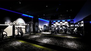 A gym with various exercise equipment, a checkered wall, and the name 'BLACK GYM' on the wall.