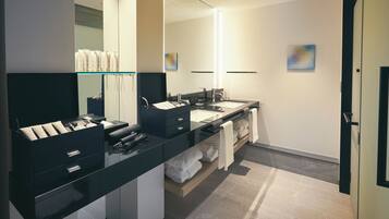 A modern bathroom with a black vanity, a large mirror, and a double sink.