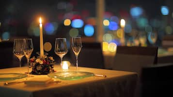 A table set for dining with wine glasses, a candle, and a floral centerpiece.
