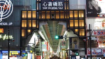 A busy urban street with a prominent building featuring a large, illuminated sign.