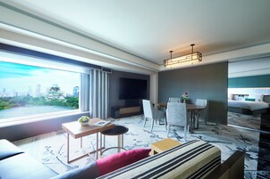 Une chambre d’hôtel moderne avec vue sur la ville, un coin repas et une chambre à coucher séparée.