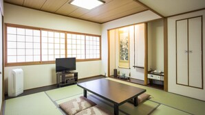 A traditional Japanese room with tatami flooring, a low table, a television, and sliding doors. - Hotel New Hankyu Osaka (Osaka)
