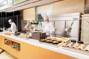A buffet setup with various food items and a chef preparing food. - Hotel New Hankyu Osaka (Osaka)