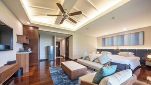 Une chambre d’hôtel moderne équipée d’un grand lit, d’un canapé, d’un bureau et d’un ventilateur de plafond.