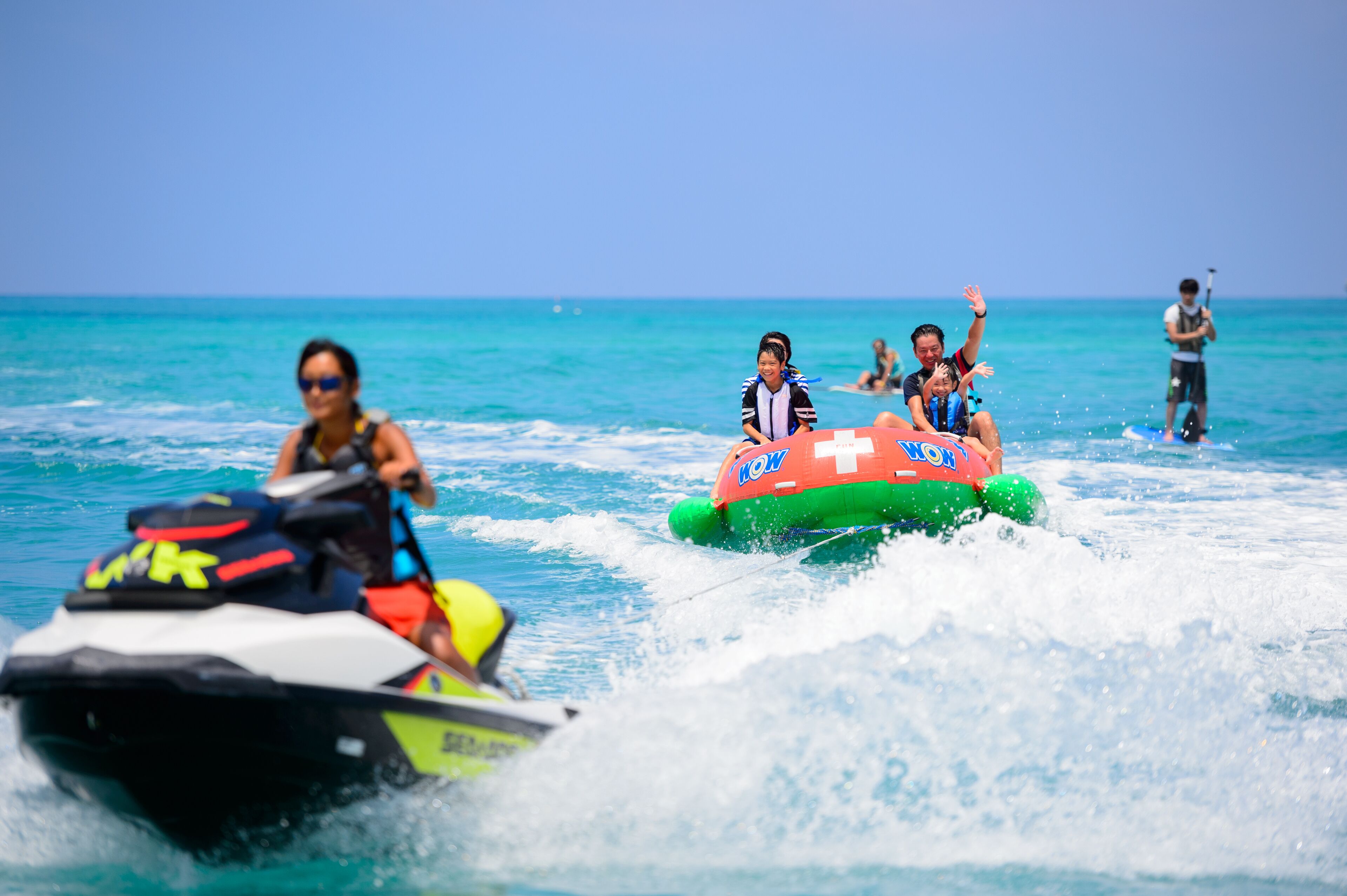 Un jet ski e una zattera gonfiabile con persone a bordo.