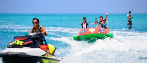 Un jet ski e una zattera gonfiabile con persone a bordo.