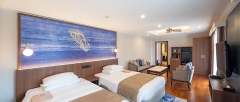 A hotel room with two beds, a large artwork on the wall, a television, and a seating area with a chair and table.