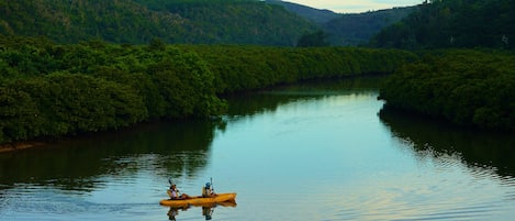 Un río tranquilo con un kayak en el centro.