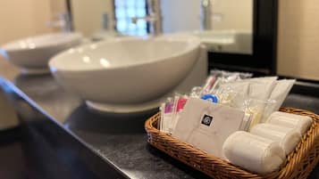 A bathroom with two sinks and a wicker basket containing toiletries.