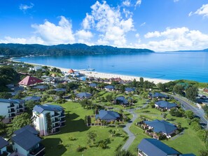 Ein Küstenresort mit mehreren Gebäuden, einem Strand und Blick aufs Meer.