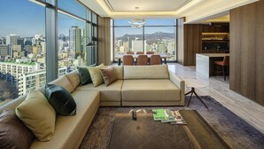 Una sala de estar moderna con un sofá grande, un comedor y una cocina.