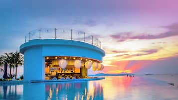 Enjoy a refreshing drink on the waterfront bar's balcony overlooking the pool and serene surroundings.
